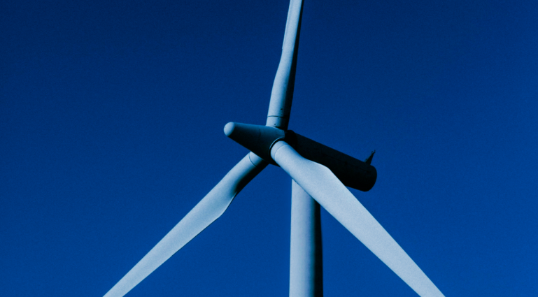 Wind turbine with sunset sky, representing global energy infrastructure.